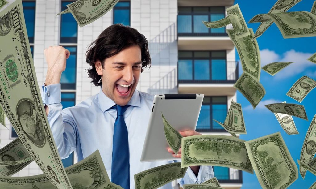 a man holding a tablet with money bills falling from above